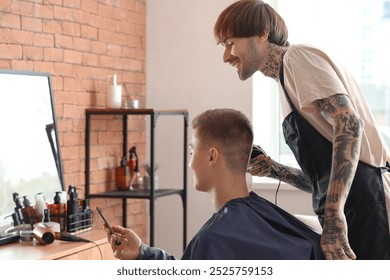 Male client with mobile phone showing hairstyle example to hairdresser in barbershop - Powered by Shutterstock