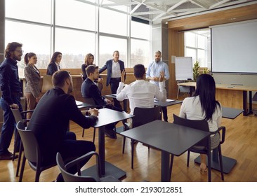 Male coach or trainer make flip chart presentation for diverse businesspeople at office meeting. Employees or colleague discuss business project strategy or idea on team briefing. Teamwork concept. - Shutterstock ID 2193012851
