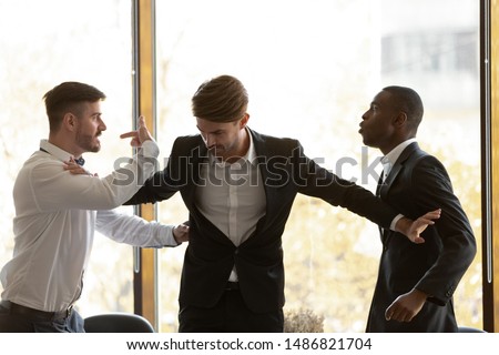 Male colleague set apart angry diverse business men coworkers argue fighting at corporate office meeting, mad employees quarreling shouting having conflict at work, racial hatred harassment concept