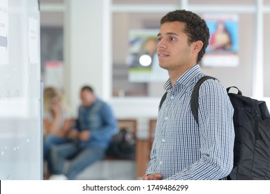 Male College Student Looking At Notice Board