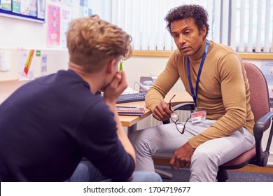 Male College Student Meeting With Campus Counselor Discussing Mental Health Issues