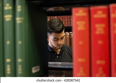 Male College Student Seen In The Library, Framed By Books