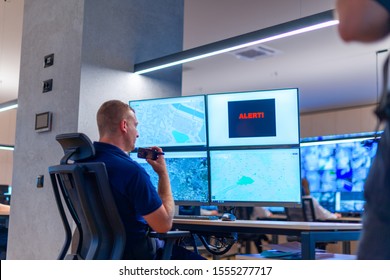 Male Computer Operator Monitoring From A Security ( Computer, Logistic ) Center. Alarm Signal On The Screen