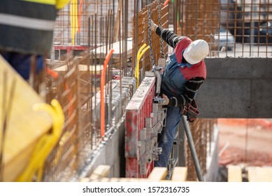 Male Construction Worker Installing Concrete Retaining Wall Rebar On Construction Site