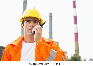 Male Construction Worker Wearing Reflective Workwear Communicating On Two Way Radio At Site