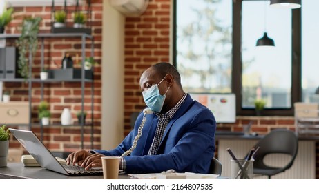 Male Consultant With Face Mask Answering Landline Phone Call, Talking To Manager About Business Statistics. Using Office Telephone To Have Remote Conversation On Telework Dial Line. Tripod Shot.