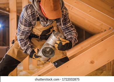 Male Contractor Assembling HVAC Pipes In Attic Of New House. 