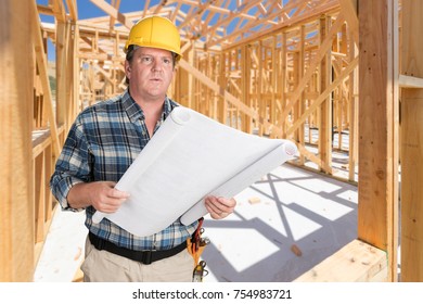 Male Contractor With House Plans Wearing Hard Hat Inside New House Construction Framing - Shutterstock ID 754983721