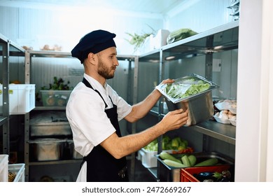 Male cook taking fresh vegetables from the pantry while working in restaurant kitchen.  - Powered by Shutterstock