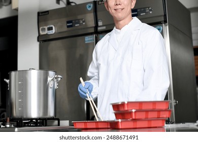 Male cooking staff packing food into bento boxes - Powered by Shutterstock