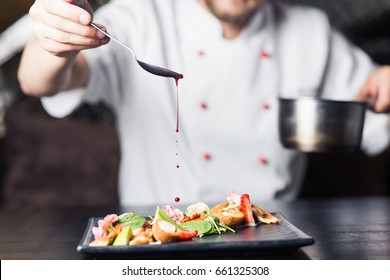 Male Cooks Preparing Meat In The Restaurant Kitchen