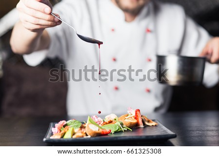 male cooks preparing meat in the restaurant kitchen