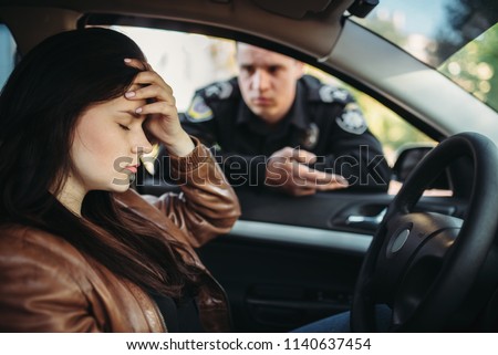 Male cop in uniform check female driver on road