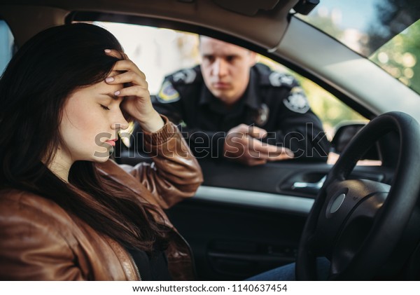 Male cop in\
uniform check female driver on\
road