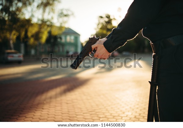 Male cop in uniform with\
gun in hands