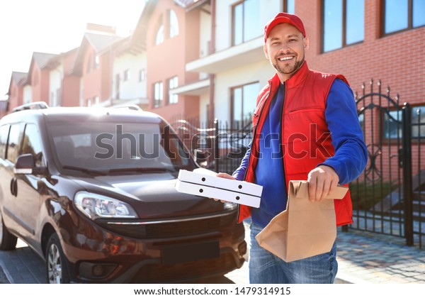 Male courier\
delivering food in city on sunny\
day