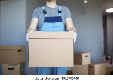 Male courier is holding large cardboard box. Cargo transportation services concept