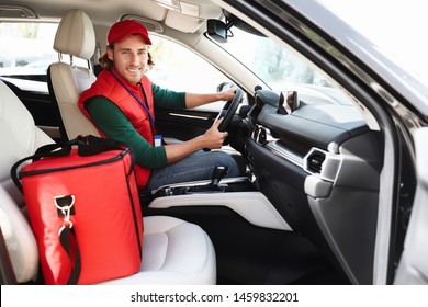 Male Courier With Thermo Bag In Car. Food Delivery Service