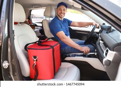 Male Courier With Thermo Bag In Car. Food Delivery Service