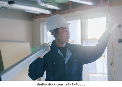 Male craftsman carrying materials at a construction site - Powered by Shutterstock