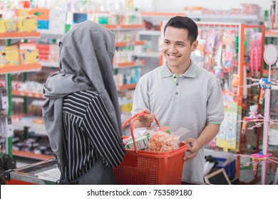 Male Customer Smiling To Female Shop Cashier At Supermarket