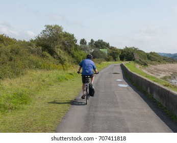 Male Cycling Along The Tarka Trail, Part Of The South West Coast Path, On The Estuary Between Braunton And Barnstaple In North Devon, England, UK