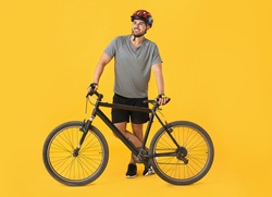 Male Cyclist With Bicycle On Color Background