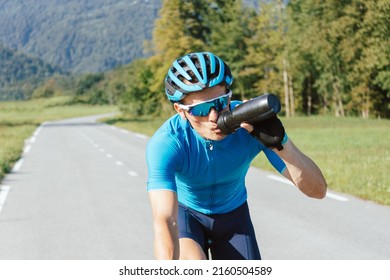 Male cyclist drinking water from bottle during high-intensity pedaling, tracking shot.