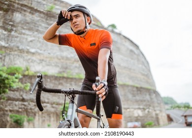 Male Cyclist Feeling Tired And Wipe His Sweat