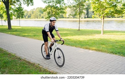 A Male Cyclist In A Helmet Rides A Bicycle, Training In The City.