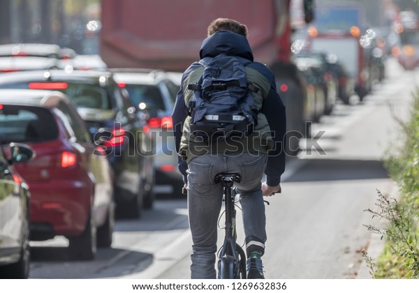 male cyclist passing traffic\
jam