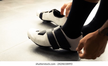 Male cyclist putting on cycling shoes and preparing to go out for training in the mountains of Medellin, Colombia - Powered by Shutterstock