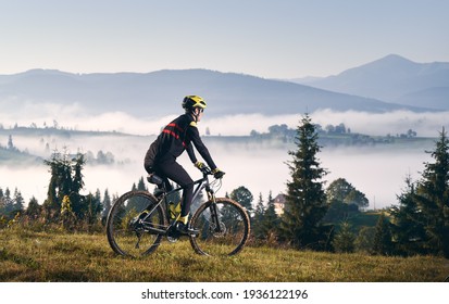 Male cyclist riding bicycle in mountains.