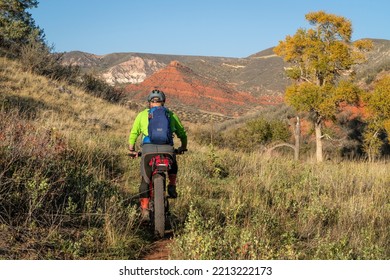 Male Cyclist Is Riding A Fat Mountain Bike On A Single Track Trail In Red Mountain Open Space In Colorado, Fall Scenery