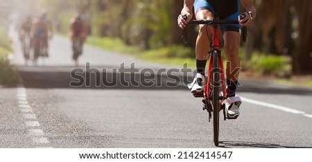 Male cyclist riding racing bicycle, man cycling on countryside summer road. Training for triathlon or cycling competition