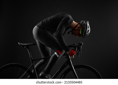 Male Cyclist Riding Road Bicycle On Black Background