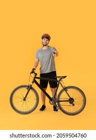 Male cyclist showing thumb-up on color background