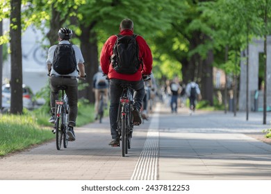 male cyclists with backpacks on bike path in avenue - Powered by Shutterstock