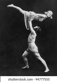 Male dancer holding female dancer aloft