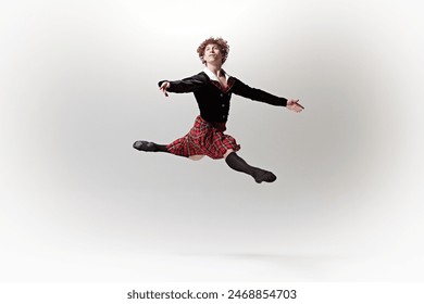 Male dancer in tartan kilt and black jacket captured mid-leap, his form showcasing strength and grace against white studio background. Concept of art, fusion of classic and modernity, elegance. - Powered by Shutterstock