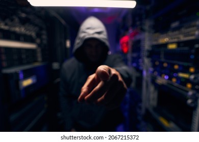 Male in data center showing threatening hand gesture