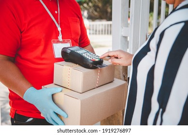 Male delivery workers wear sanitation faces and wear gloves, deliver goods or parcels, delivery service for users to pay via credit card for convenience and forgiveness during covid19.