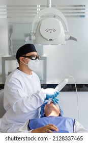 Male dentist performing a scan for the 3d model of a female patient's mouth. Dental clinic concept
