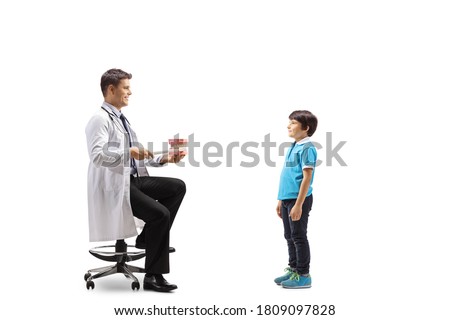 Male dentist showing theeth brushing with a model jaw to a boy isolated on white background
