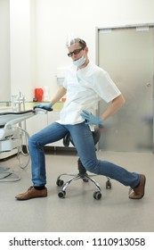 Male Dentist Stretching His Legs  In The Office During Break