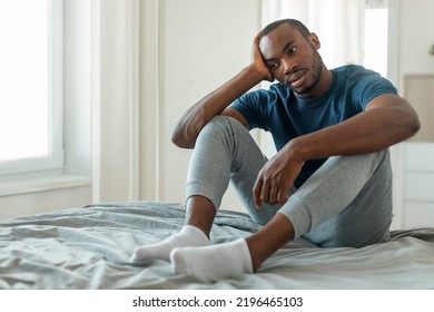 Male Depression Problem. Unhappy Black Male Thinking About Loneliness Sitting On Bed In Modern Bedroom Indoors. Negative Thoughts And Mental Health Issues Concept