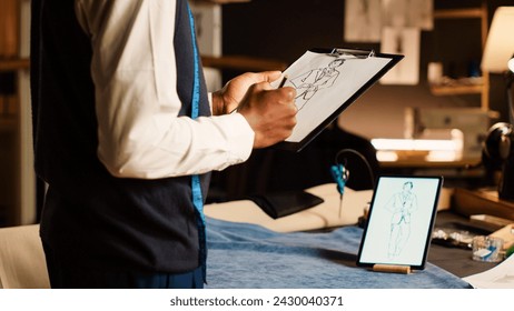 Male designer drawing model sketch for handmade fashion collection, textile crafting industry. Luxury couturier creating sketches of clothes for modern items creation in atelier. Close up. - Powered by Shutterstock