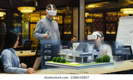 Male designer uses VR headset and wireless controllers, presents smart home exterior design project in virtual reality to coworkers. Modern hi-tech company. 3D hologram. Future digital technologies. - Powered by Shutterstock