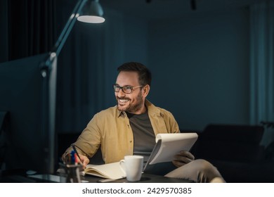 Male designer working at home office on new ideas.Portrait of a smiling man working at home on some new project. - Powered by Shutterstock