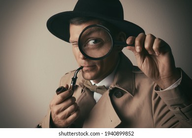 Male detective with smoking pipe looking through magnifying glass on beige background
